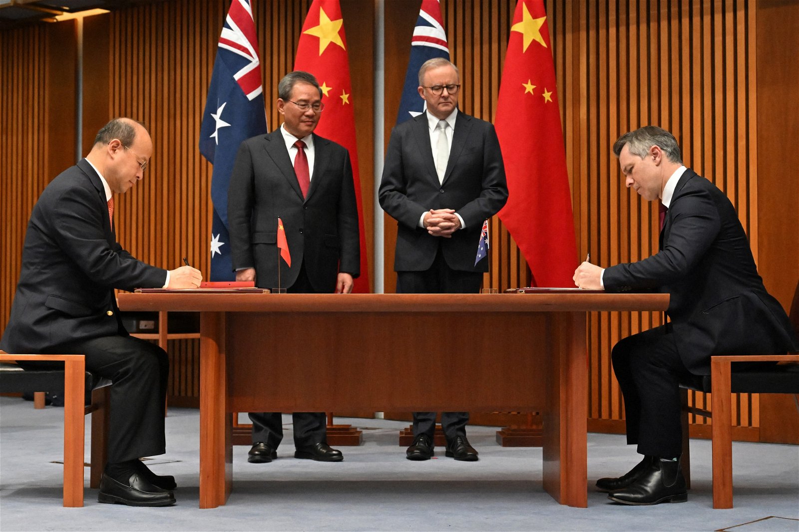 中国总理李强（左2）和澳洲阿尔巴尼斯（右2）周一在堪培拉的澳洲国会大厦，见证中国驻澳洲大使肖千（左）和澳洲教育部长克莱尔签署协议文件。（图取自法新社）