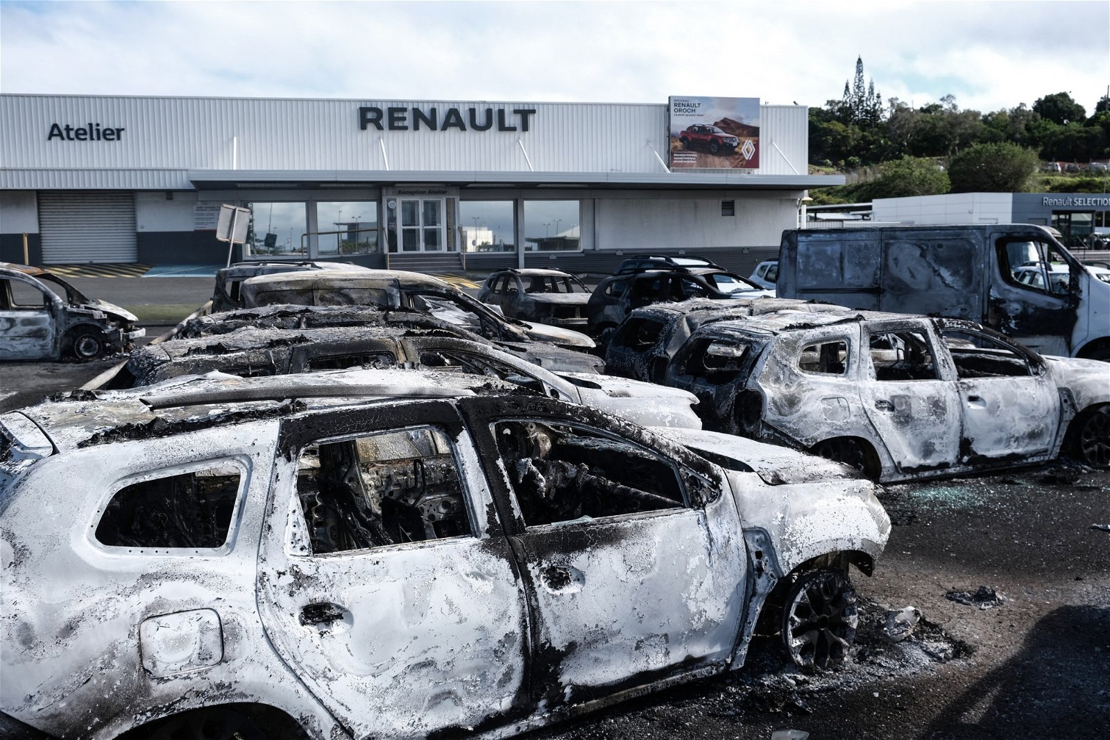 努美阿一家汽车经销店在周一的骚乱中遭到纵火，店外的汽车全被烧毁。（图取自法新社）