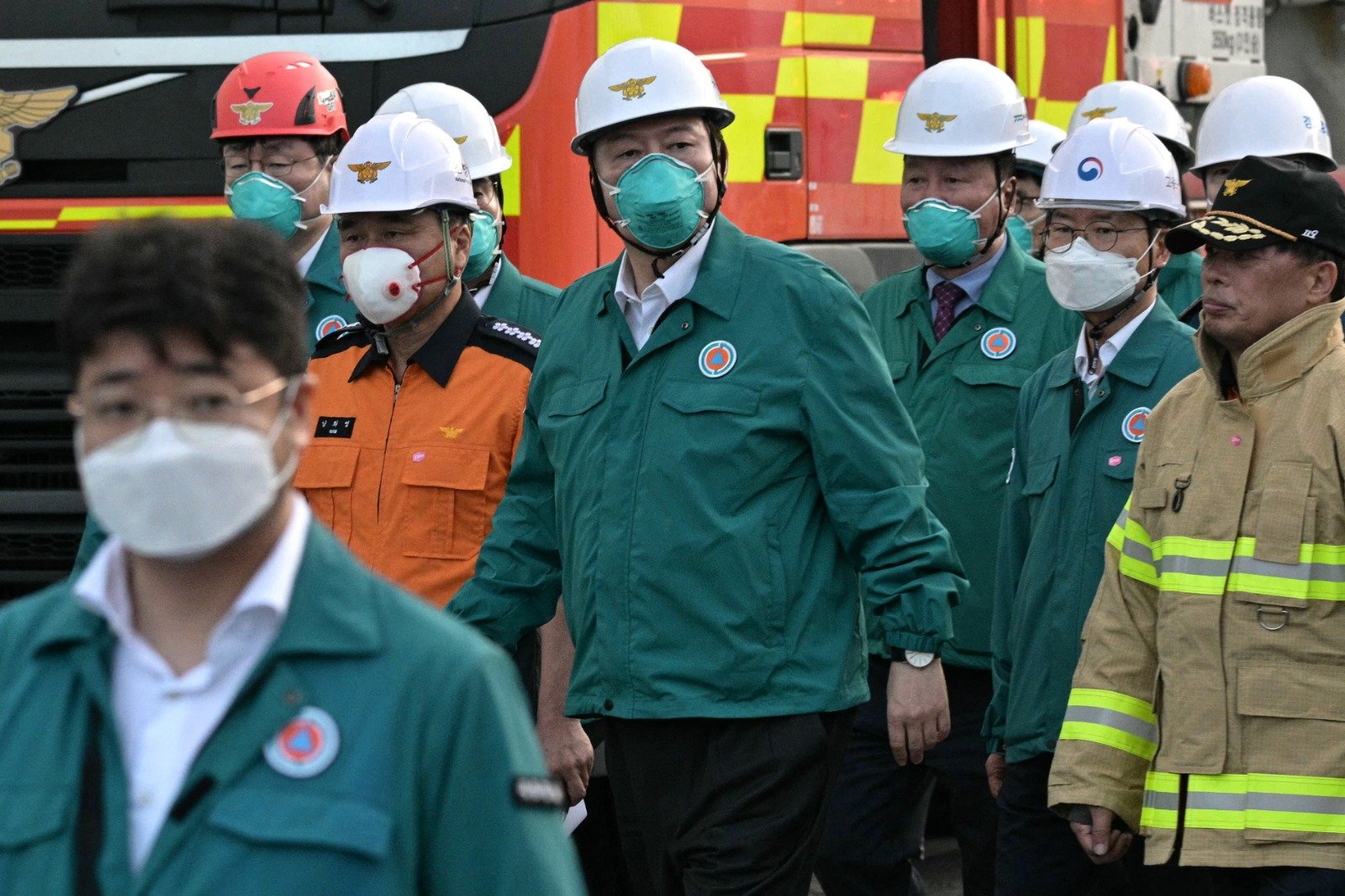 韩国总统尹锡悦（中）周一晚视察事故现场，命令当局检查处理化学品的类似工厂，并采取“措施防止此类事故再次发生”。（图取自法新社）