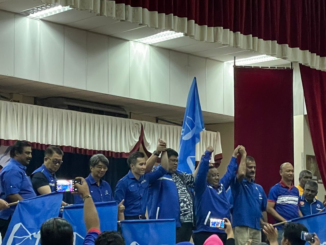 阿都拉勿（左5）在移交竞选机制旗帜后，高举沙里尔韩丹（左4）的手。
