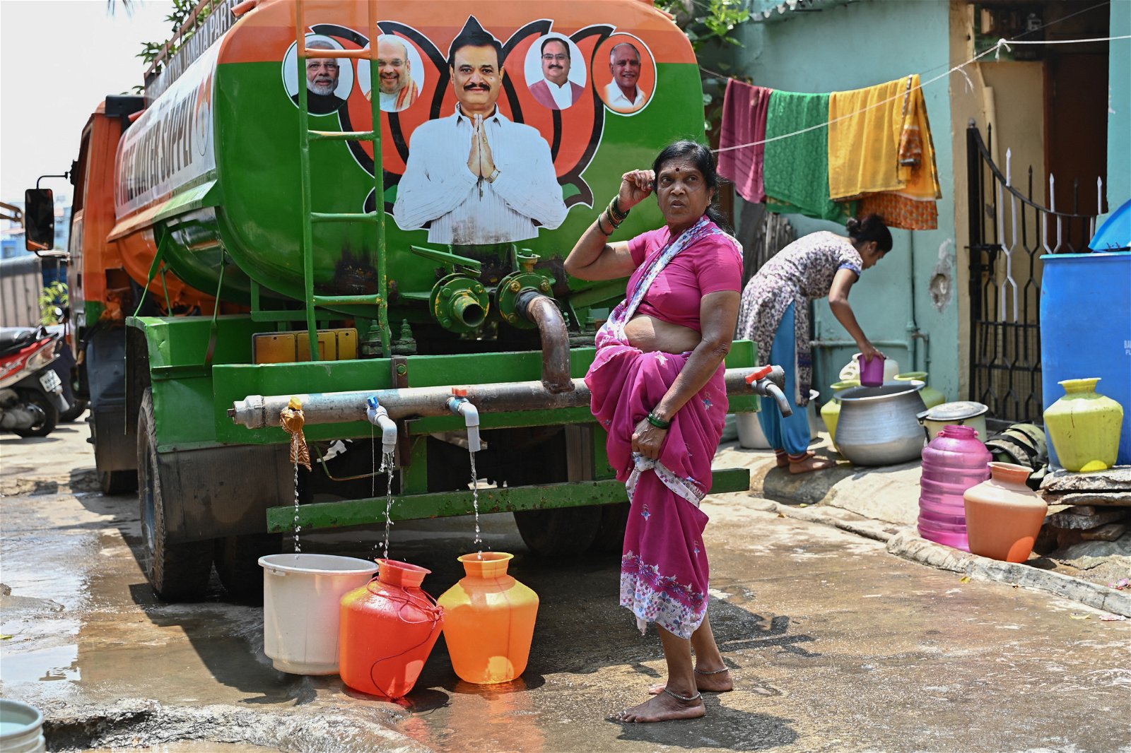 班加罗尔的妇女从政党派来的水槽车，收集免费水。（图取自法新社）