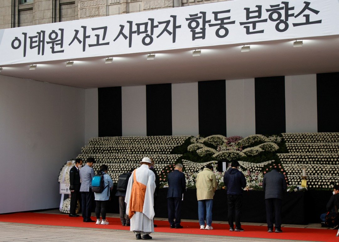 大批民众在周一前往设置在首尔广场的灵堂，吊唁梨泰院踩踏事件中的遇难者。（图取自路透社）