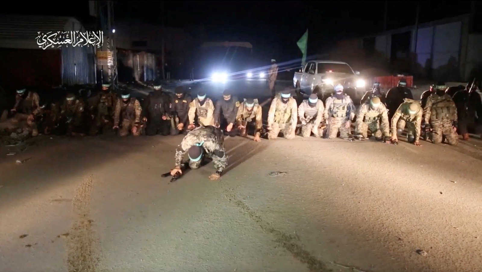 哈马斯武装分子于周三晚，将第6批人质都移交给红十字国际委员会后就地祈祷。（图取自哈马斯军事翼/路透社）