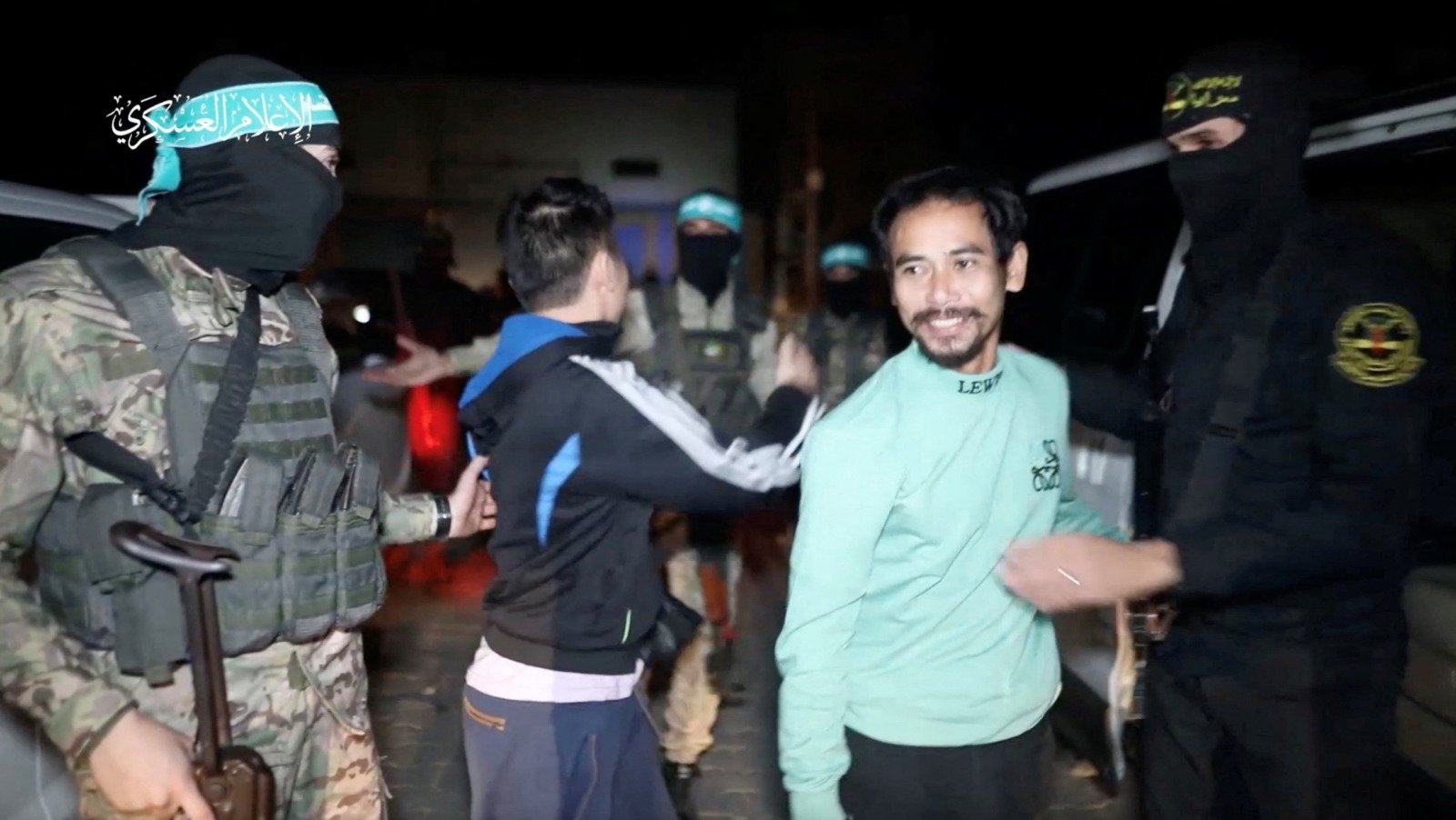 哈马斯在周三晚释放第6批人质，其中包括4名泰国人和两名俄罗斯人。图为哈马斯将泰国人质移交给红十字国际委员会时，其中一人转身向哈马斯武装分子道别。（图取自哈马斯军事翼/路透社）